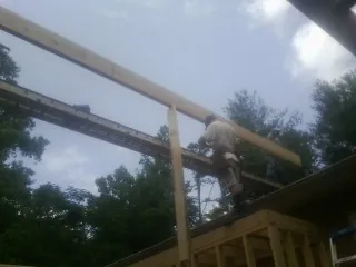 Carpenter setting a ridge beam over a new addition frame — Ice Dam Removal by Roofing Brothers in Camp Douglas