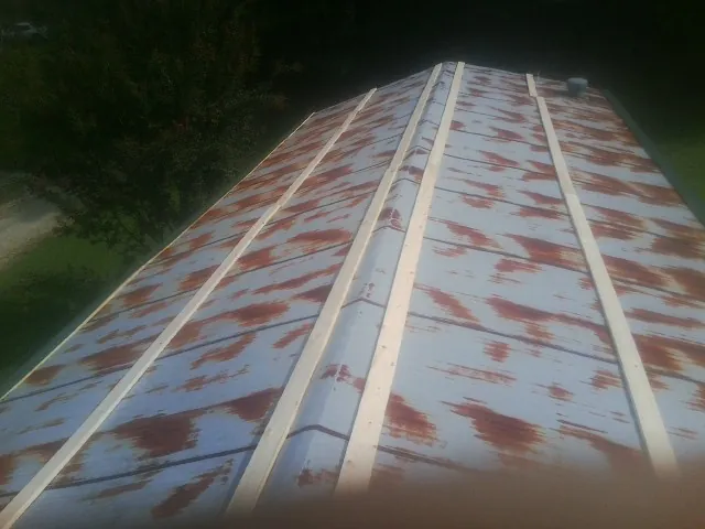 Rusted metal roof panels with new wood purlins before replacement — Storm Damage Roof Repair in Camp Douglas by Roofing Brothers