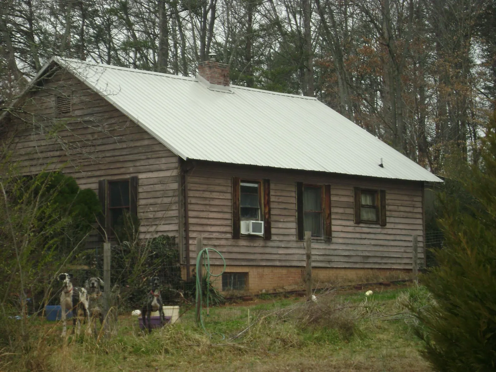 White metal roof on an old wood sided farmhouse, from a Metal Roof Installation job in Camp Douglas